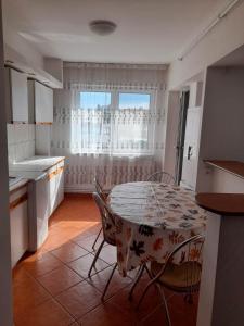 een keuken met een tafel en stoelen en een raam bij Spacious 4 rooms downtown apartment in Pitesti in Piteşti