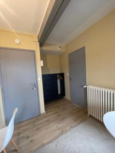 ein leerer Raum mit einer Tür und einem Tisch und Stühlen in der Unterkunft Petit Studio Centre-Ville n°14 in Besançon