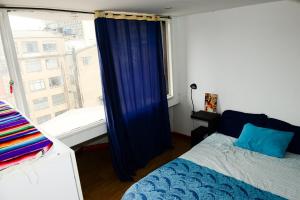 een slaapkamer met een bed en een groot raam bij Acogedor Apartamento La Candelaria 2 Habitaciones EC52 in Bogota