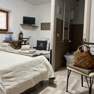 1 dormitorio con cama, silla y bañera en B&B Casa de' Trinci, en Foligno