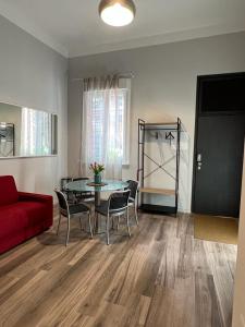 - un salon avec un canapé rouge, une table et des chaises dans l'établissement Fiori 3 Apartment, à Milan