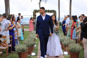Uma noiva e um noivo a caminho do altar no seu casamento. em EnseadaPrime eventos e casamentos beira-mar na Praia Enseada dos Corais em PE em Cabo de Santo Agostinho