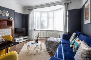 a living room with a blue couch and a tv at Stylish Newcastle Gem - Sleeps 9 - Parking in Newcastle upon Tyne
