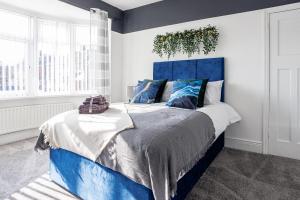 a bedroom with a blue bed with a plant on the wall at Stylish Newcastle Gem - Sleeps 9 - Parking in Newcastle upon Tyne