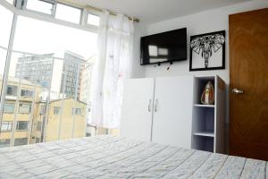 a bedroom with a bed and a large window at Acogedor Apartamento La Candelaria 2 Habitaciones EC52 in Bogotá