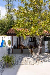 ein Baum vor einem Haus mit einem Pavillon in der Unterkunft Piccola Villa Adriatic, with heated swimming pool, Opatija in Ičići