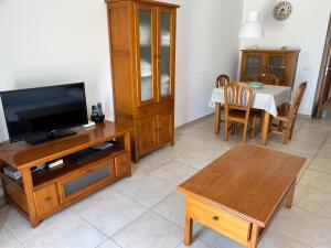 a living room with a tv and a dining table at Apartamento Es Calo (Edificio Cavall de Llevant) in Es Calo