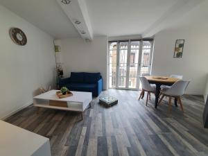 - un salon avec un canapé bleu et une table dans l'établissement Appartement meublé, bord de seine, à Duclair