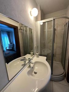 a bathroom with a sink and a shower and a mirror at Paperon Hotel in Limonlu