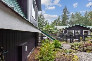 a house with a fence next to a yard at Salt Spring Carriage House B&B in Ganges