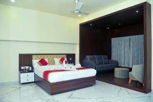 Hotel Royal Inn في Mudhol: غرفة نوم بسرير كبير وكرسي