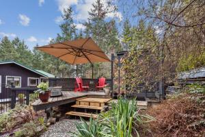 a patio with two chairs and an umbrella at Salt Spring Carriage House B&B in Ganges +37 photos