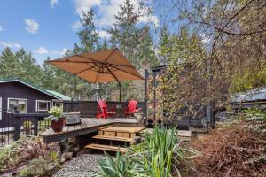 a patio with two chairs and an umbrella at Salt Spring Carriage House B&B in Ganges