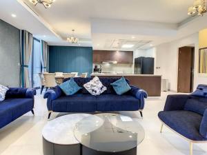 a living room with a blue couch and a table at Key View - Casa Flores Villa in Dubai