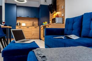 a laptop sitting on a blue couch in a living room at Premium Wrocławska Apartament Parking in Bydgoszcz