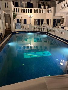 a large swimming pool with blue water in a building at Hotel Porto Perissa in Perissa