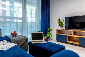 a living room with a laptop on a blue couch at Premium Wrocławska Apartament Parking in Bydgoszcz