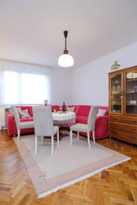 sala de estar con sofá rojo, mesa y sillas en The Cosmic Gate Apartments, en Visoko