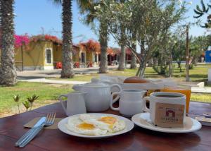 una mesa con dos platos de huevos y café. en La Estancia Chincha Hotel, en Chincha Alta