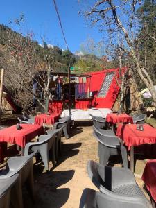 a group of tables and chairs with red table cloth at TravelON Manali Glamping Resort in Manāli