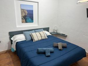 un letto blu con due cuscini sopra di Apartamento Sa Ginebra, Cala Saona a Cala Saona