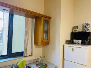 a kitchen with a window and a refrigerator at the valley in Il-Gżira