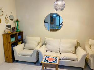 a living room with two chairs and a mirror at the valley in Il-Gżira +1 photo