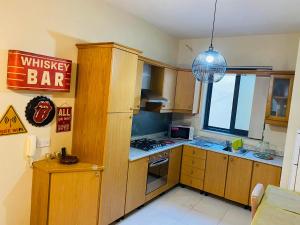 a kitchen with wooden cabinets and a sign that reads whiskey bar at the valley in Il-Gżira