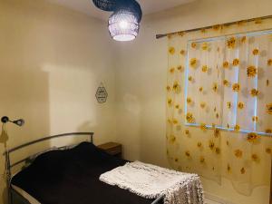 a bedroom with a bed and a curtain with sunflowers at the valley in Il-Gżira