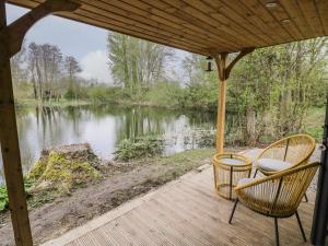 a porch with two chairs and a view of a lake at Dragonfly in Rugby