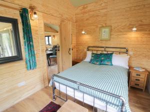 a bedroom with a bed in a room with wooden walls at Dragonfly in Rugby