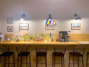 a bar with four stools in front of a counter at Hostel 47 in Batumi