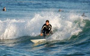 a man riding a wave on a surfboard in the ocean at Cozy Apartment with Patio near Carcavelos Beach in Carcavelos