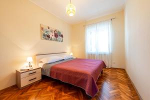 a small bedroom with a bed and a window at Apartment Miljas in Cavtat