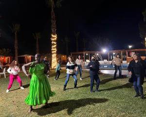 un grupo de personas bailando en el césped por la noche en La Estancia Chincha Hotel, en Chincha Alta