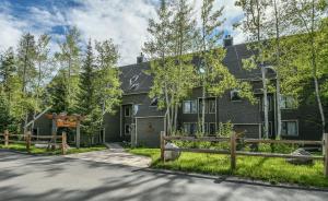 a black house with a fence in front of a road at Pines 2086 in Keystone