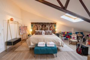 una camera da letto con un grande letto con due ottomane blu di L’Avant Scène - Loft de Luxe - Atelier d'artiste ad Avignone