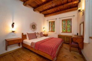 a bedroom with a bed and a desk and window at Watermill Villa & Hotel Faralya in Fethiye