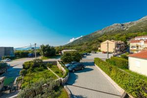 a street in a small town with a mountain in the background at Apartment Miljas in Cavtat