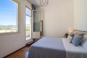 ein Schlafzimmer mit einem großen Bett und einem großen Fenster in der Unterkunft Capitana Rooms in Costa degli Angeli