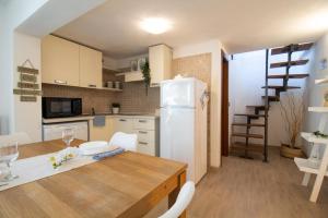 eine Küche mit einem Tisch und einem weißen Kühlschrank in der Unterkunft Capitana Rooms in Costa degli Angeli