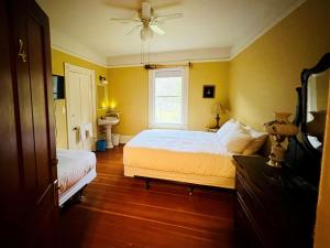 a yellow bedroom with a bed and a window at Sasquatch Crossing Eco Lodge B&B in Harrison Mills