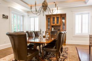 a dining room with a table and leather chairs at Beacon Hill in Carriage House at Oak Street Mansion in Kansas City