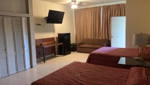 a hotel room with two beds and a television at HOTEL PLAZA RIVIERA in Matamoros