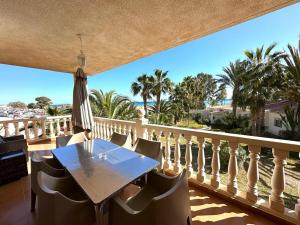 a table on a balcony with a view of the ocean at Apartamentos Oasis de las Palmeras in Bolnuevo