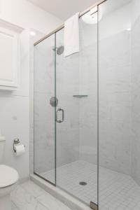 a glass shower stall in a bathroom with a toilet at Roanoke at Oak Street Mansion in Kansas City