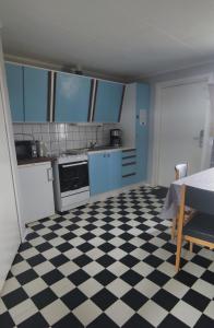 eine Küche mit schwarz-weiß kariertem Boden in der Unterkunft Stugor utanför Skövde 2 och 4 in Skövde