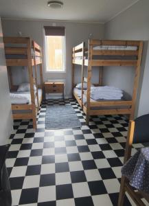 a room with bunk beds and a checkered floor at Stugor utanför Skövde 2 och 4 in Skövde
