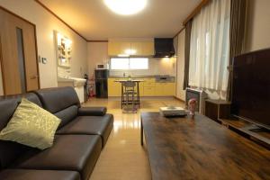a living room with a couch and a table at Stay In Miyashita in Asahikawa