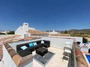 um pátio com um sofá e uma cadeira no telhado em Awesome 5* Lux Villa - El Valle - Pool/Jacuzzi em Múrcia